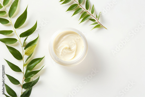 Still life of cosmetic jar with cream with leaves on white background, skin care concept, top view