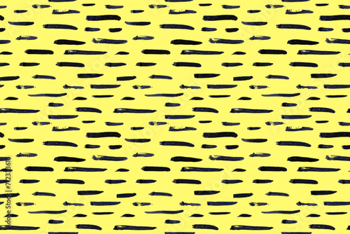 Thin horizontal lines pattern on yellow background. Hand drawn small black dash seamless texture. Black linear ornament. Memphis style background with brush stripes. Abstract modern vector texture.
