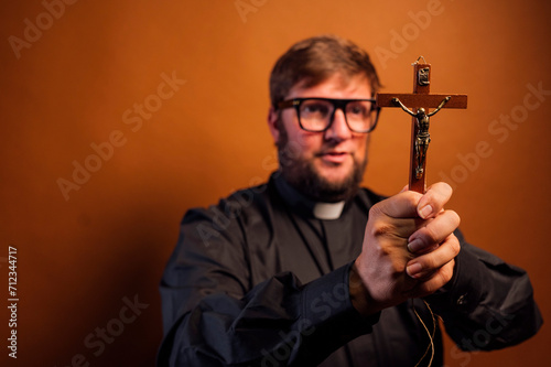 Portrait of an exorcist priest with crucifix and black shirt.