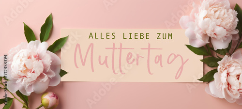 Alles Liebe zum Muttertag Feiertag Grußkarte - Papier, Rahmen mit deutschem Text und Pfingstrosen auf pink aprikot Tisch Hintergrund, Draufsicht