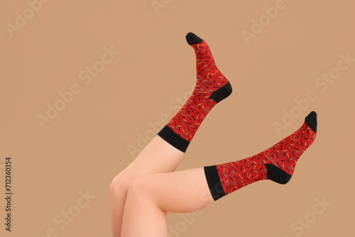 Legs of young woman in socks on beige background