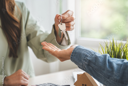 Realtor agent giving a key of apartment to new owner after signed lease agreement.