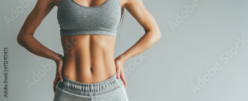 Generative AI, Sporty woman with great abdominal muscles shows stomach in sportswear on neutral background