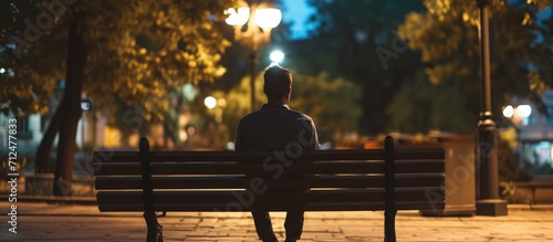 A man on a bench speaking about work matters in the evening.