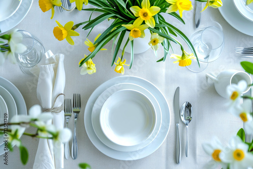 table setting. Plates and cutlery with spring flowers daffodils on a light table