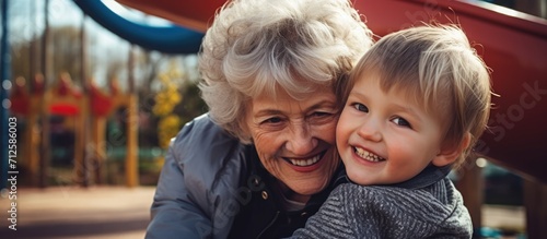 Grandmother bonding with grandson at park playground. Friendship and caregiving for children. Seeking trustworthy family assistant.