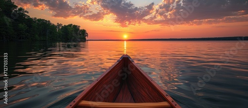 Stunning sunset on serene Kentucky lake, viewed from an old canoe.
