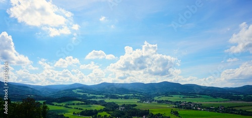 Panorama na góry i błękitne niebo. W otoczeniu gór widać liczne zabudowania.