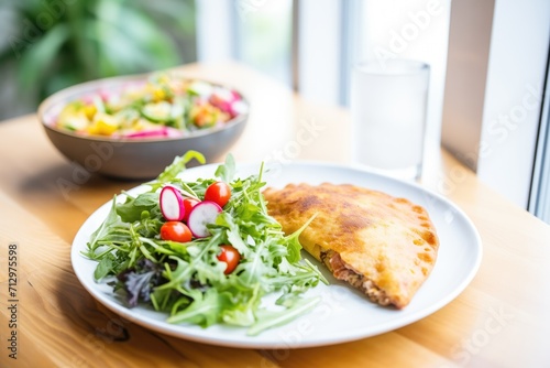 calzone with a side salad on a plate