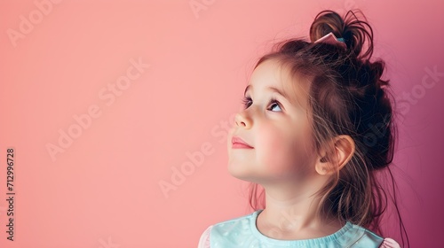 Close up potrait of cute little girl looking above. Concept of curious ,imiginative, new idea, solution from young and smart kids. Pastel color background with copy space.