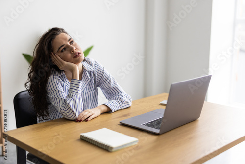 Overworked and tired businesswoman sleeping over a laptop at work in her office
