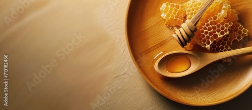 honeycomb with a wooden spoon spindle on a plate no people. Copy space image. Place for adding text