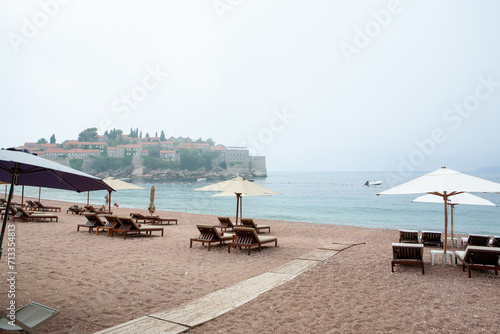 Beach chairs and with umbrellas on the St. Stephen island background for publication, design, poster, calendar, post, screensaver, wallpaper, postcard, banner, cover, website. High quality photo