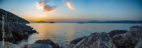 A panoramic view of the sunset over the Saronic Sea from Kamini harbor on Hydra Island, Greece