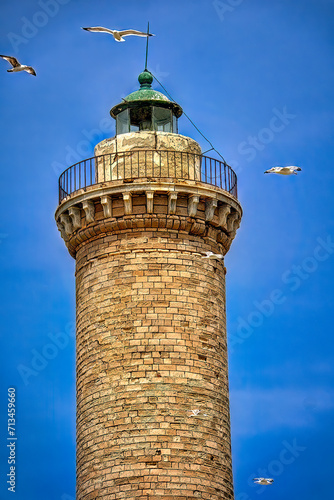 The picturesque Lighthouse of Ermoupolis in Syros island with seagulls flying around, Cyclades, Greece