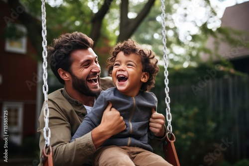 Father's Day. Diverse black dad with his son on a swing in backyard garden, smiling and looking happy, spending quality time together. 