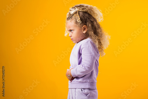 Child girl feeling abdominal pain, keeping hands on stomach because indigestion, painful illness feeling unwell. Ache concept.