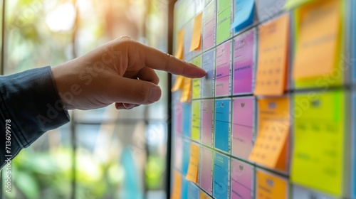 Reminder appointment calendar for organizer agenda time table and event planner organize and schedule activity. Man pointing on calendar or schedule to marking color paper note target date appointing.