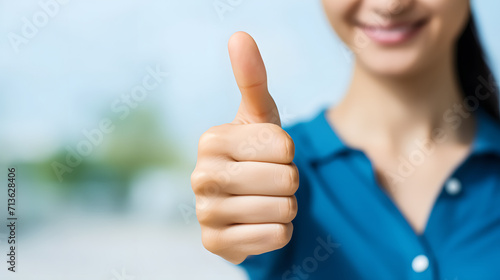 A detailed view of a woman's hand offering a thumbs up, indicating approval or showing that she likes something