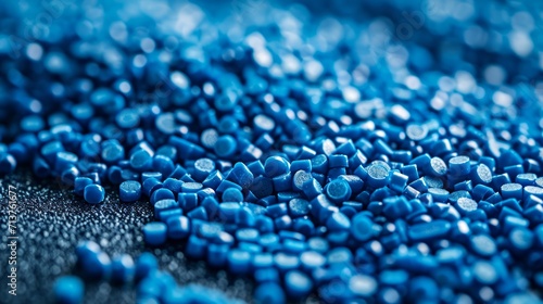 Close-up of shiny blue plastic pellets on a smooth matte surface