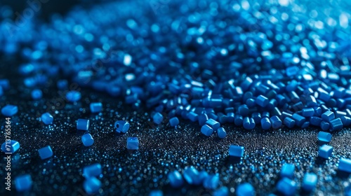 Close-up of shiny blue plastic pellets on a smooth matte surface