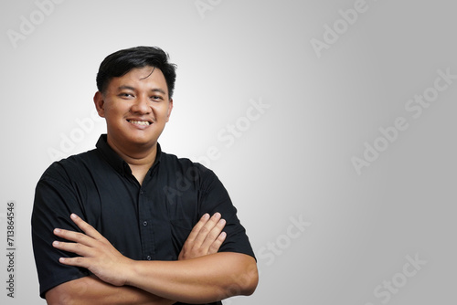 A handsome Asian man is crossing his arms, isolated on a white background