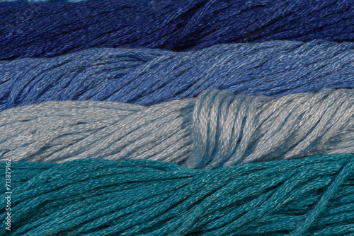 Niebieskie tło struktura skręconych nici sznurków, poziome pasy w różnych pastelowych odcieniach 