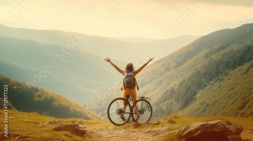 Happy woman with open arms on bike high in mountains. Travel summer lifestyle.