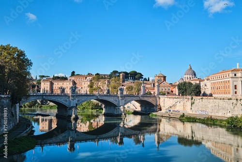 View of the Tiber river, The Sant Angelo Bridge and St. Peters Basilica in the far background, Rome, Italy