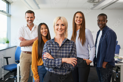 Group portrait of female entrepreneur with group of colleagues standing together at office