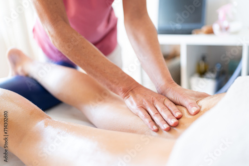 Crop masseuse rubbing oily skin of client during body massage in clinic