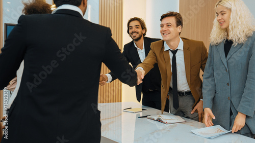 Ornament meeting room with group of diversity business people or office worker college shake hand after make successful business agreement deal. Business professionals greeting in workplace.
