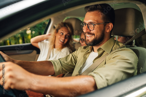 Father driving a car while the whole family is going on a weekend trip away