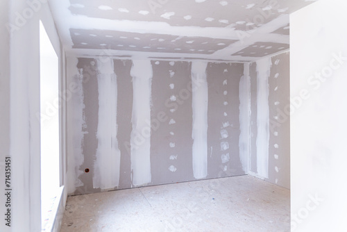 Interior of a house under renovation with drywall installation and joint compound application