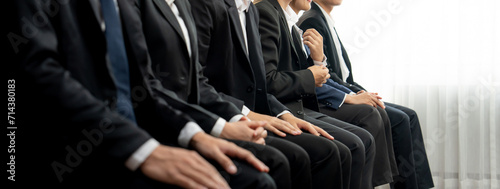 Group of interviewee candidate in formal suit line up for interview sitting on the chair. Job opportunity recruitment for HR agency and vacancy concept. Shrewd
