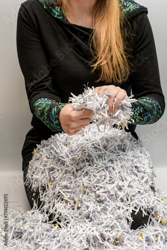 Kobieta niszczy papierowe dokumenty 