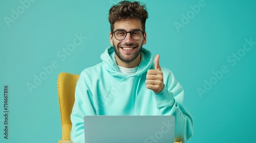 Full body young programmer happy caucasian IT man wear mint hoody sit in bag chair hold use work point finger on laptop pc computer isolated on plain solid white background People lifestyle concept.