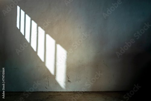 DARK CELL IN JAIL OR PRISON WITH SUNLIGHT THROUGH THE BARRED WINDOW. PRISONER SERVING SENTENCE.