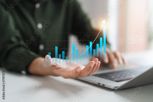Businesswoman analyzing company's business financial balance sheet working with digital augmented reality graphics, Businesswoman calculates financial data for long-term investment.