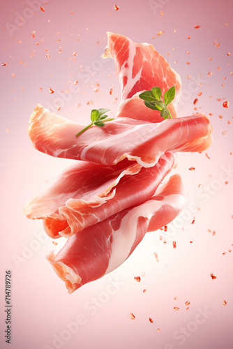 Delicate slices of prosciutto with fresh parsley leaves tumble gently, displayed on a sofy pink background. 