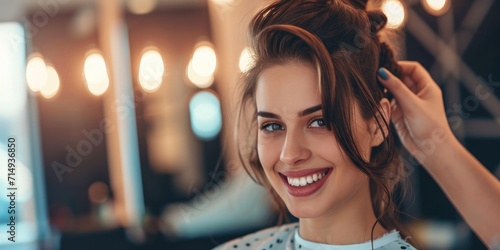 close up Young female hairdresser fixing hair of gorgeous smiling top model woman