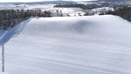 Krajobraz zimowy, śnieg na stoku górskim, drzewa, zdjęcie zrobione pod słońcem.