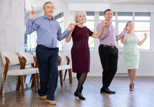 Elderly people with middle-aged man holding hands dancing hava nagila. Dance lessons for amateurs and beginners