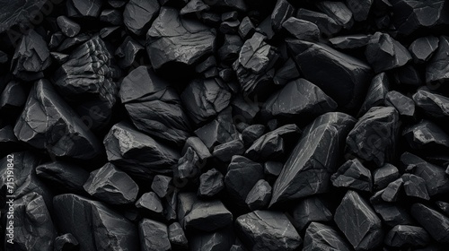 a high-resolution image displaying a variety of black stones with different textures and shapes, creating a natural, monochromatic background