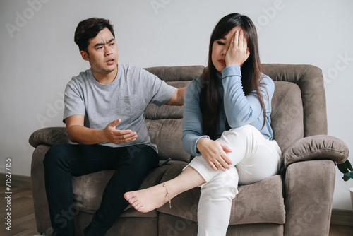 Young Asian couple having quarrel and arguing at home. Negative emotions and family problems concept
