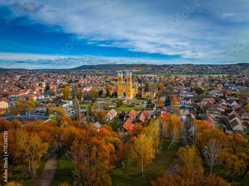 Fot, Hungary - Aerial view of the Roman Catholic Church of the Immaculate Conception (Szeplotlen Fogantatas templom) and the town of Fot on a sunny autumn day with autumn foliage and blue sky