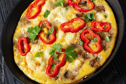 omelette with vegetables in a pan, top view