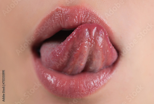 Sexy lips. Plump glossy lip. Tongue out. Closeup of female sticking tongue out and licking lips. Macro tongue lick lips. Close up of woman mouth with tongue. Sexy tongues. Sensual lips lick.