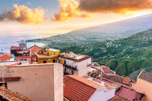 beautiful travel town view from a mountain to roofs and houses, valley and sea gulf with scenic cloudy sunrise or sunset on background of landscape