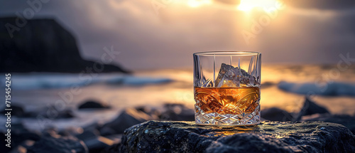 glass of whiskey shines on an ornate stone against the dark brooding light shafts in a coastline backdrop, food advertising, with empty copy space